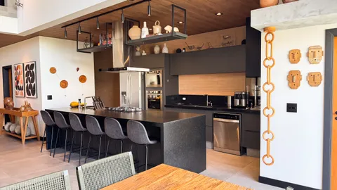 Cozinhas &mdash; Cozinha Gourmet com Ilha em Granito Escuro e Estrutura Suspensa